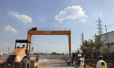 Heavy-duty gantry crane lifting materials in a manufacturing plant.
